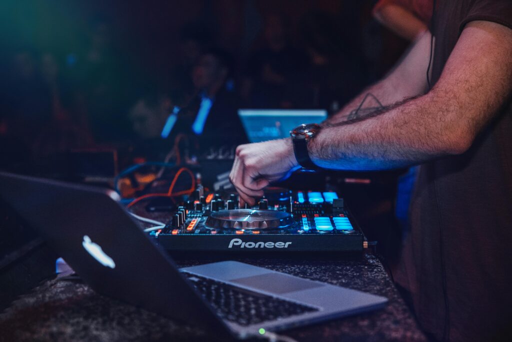 DJ performing with mixer in a vibrant nightclub setting. Perfect for entertainment and technology themes.