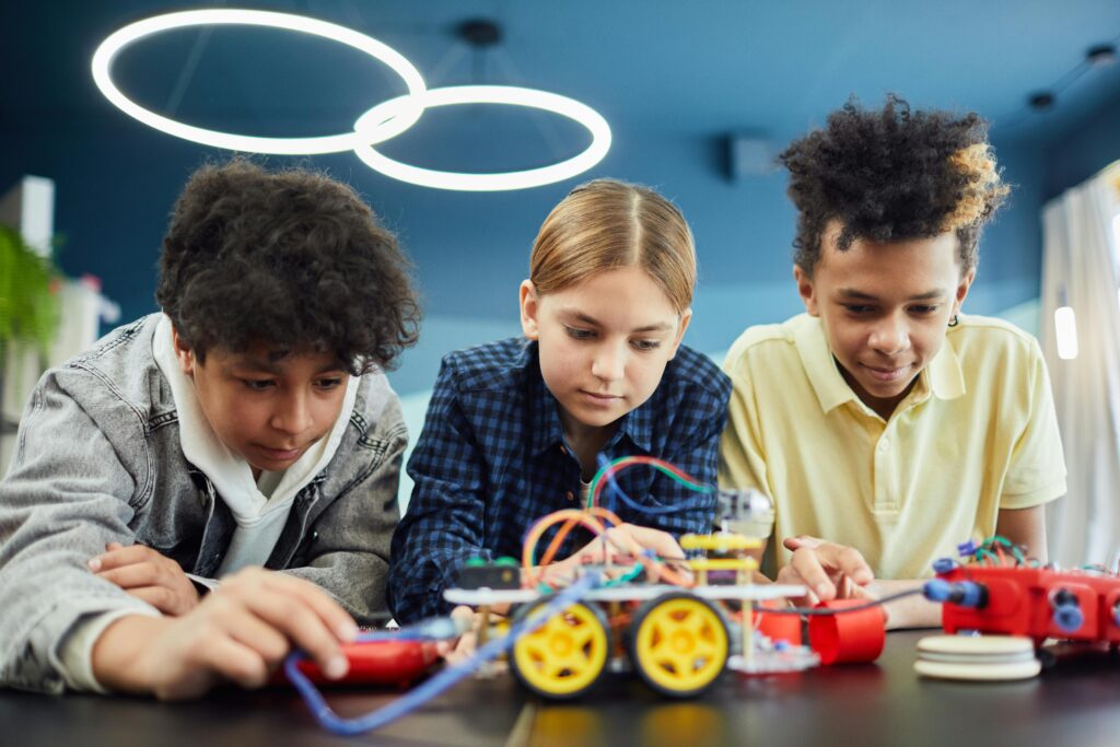 Young students focus on building a robotics project together, showcasing teamwork and creativity.