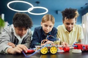 Young students focus on building a robotics project together, showcasing teamwork and creativity.